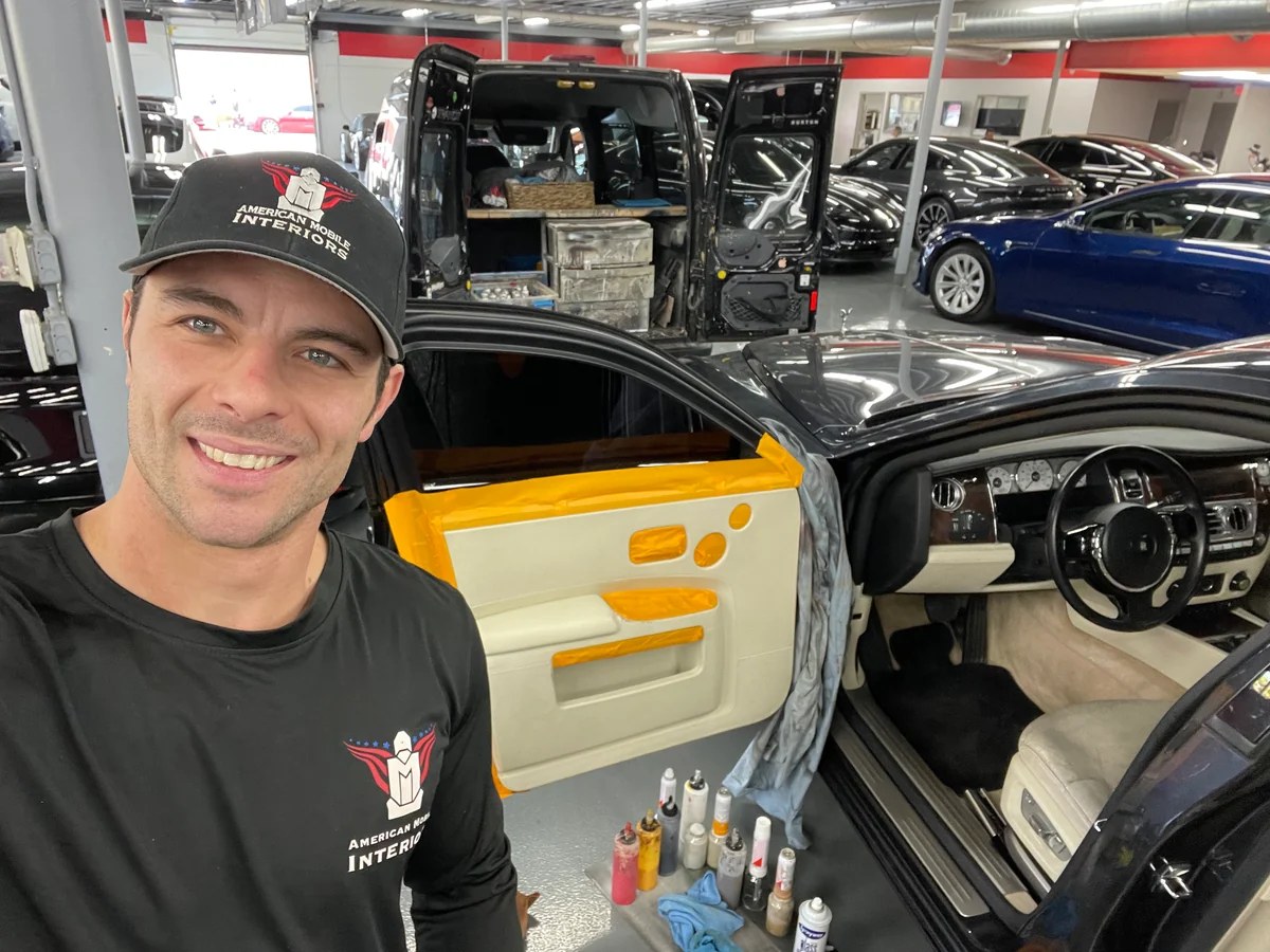 An American Mobile Interiors technician refinishing the door panel of a Rolls-Royce