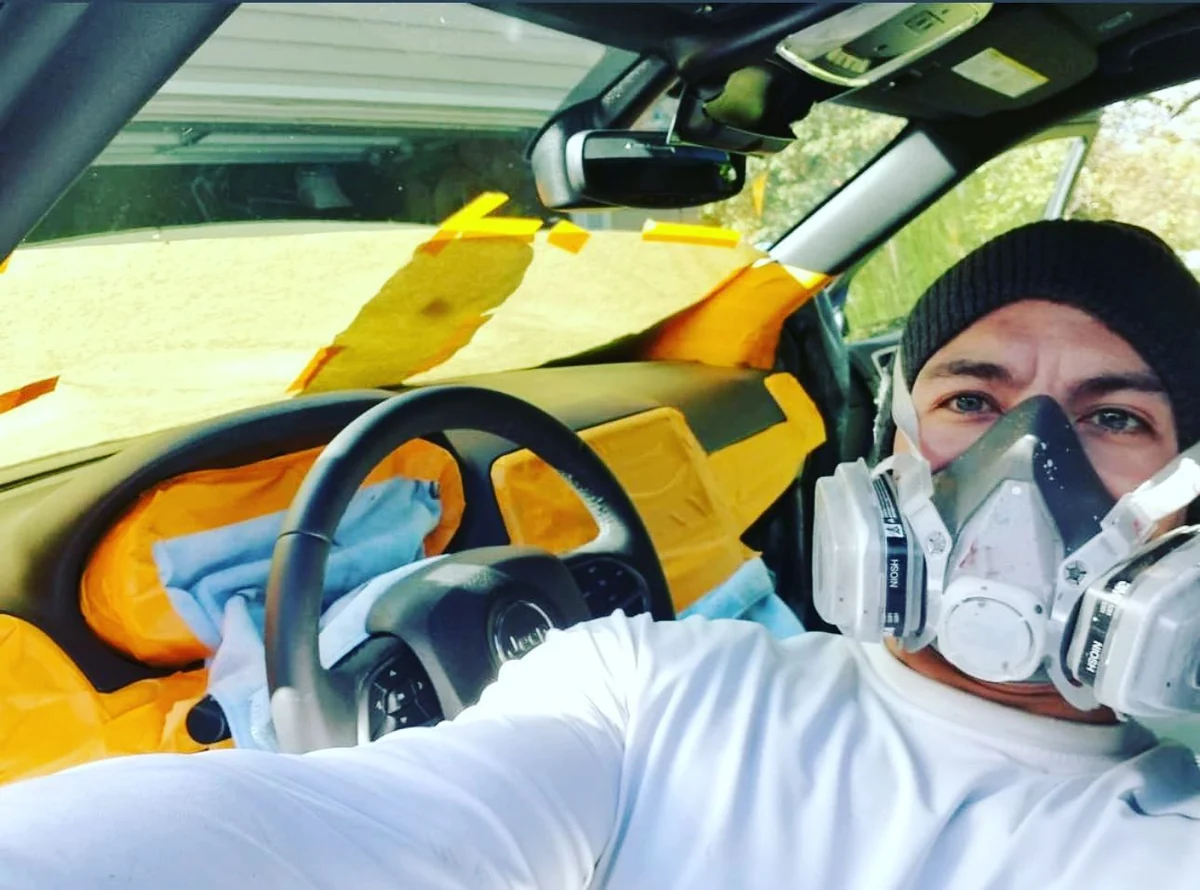Technician in a respirator masking off an interior for dye work